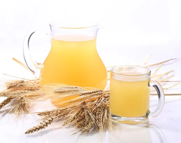Bebida de grano - kvass (kvas) en una jarra transparente sobre un respaldo blanco — Foto de Stock