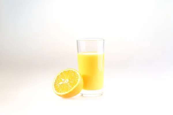 Orange juice in a transparent glass on a white background — Zdjęcie stockowe