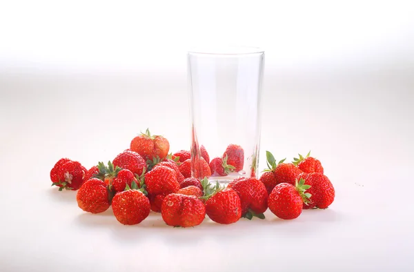 Las bayas de la fresa roja madura y el vaso transparente a wh — Foto de Stock