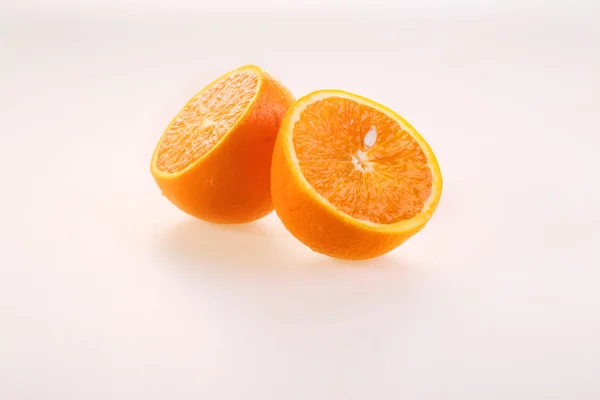 Naranja sobre un fondo blanco, mitades de una jugosa naranja madura sobre un —  Fotos de Stock