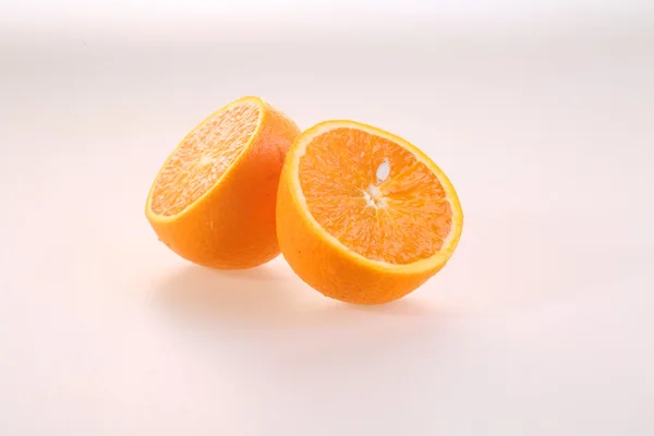 Naranja sobre un fondo blanco, mitades de una jugosa naranja madura sobre un —  Fotos de Stock