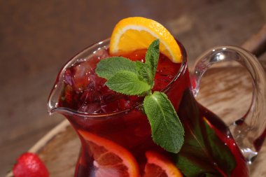 Wine of Sangrija in a transparent jug on a wooden table with an 