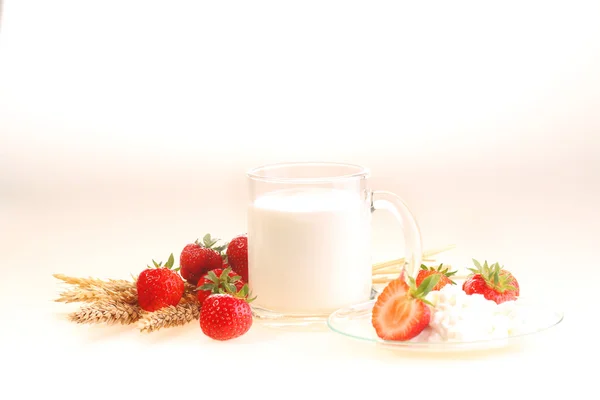 Leche y fresa sobre un fondo blanco, leche en un transparente —  Fotos de Stock