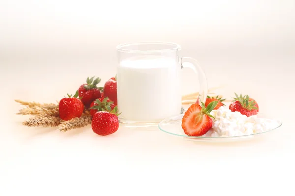 Leche y fresa sobre un fondo blanco, leche en un transparente — Foto de Stock