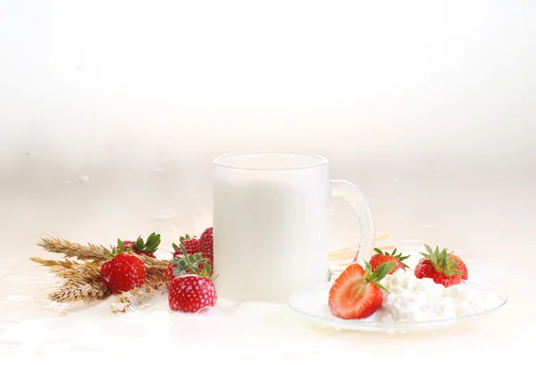 Fresa y leche sobre un fondo blanco, leche en un transparente — Foto de Stock