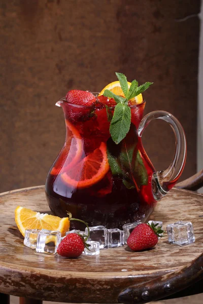 Wine of Sangrija in a transparent jug with a strawberry, an oran — Stock Photo, Image