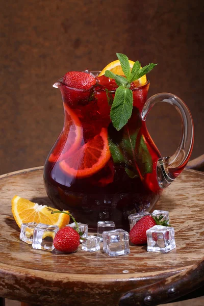 Wine of Sangrija in a transparent jug with a strawberry, an oran — Stock Photo, Image