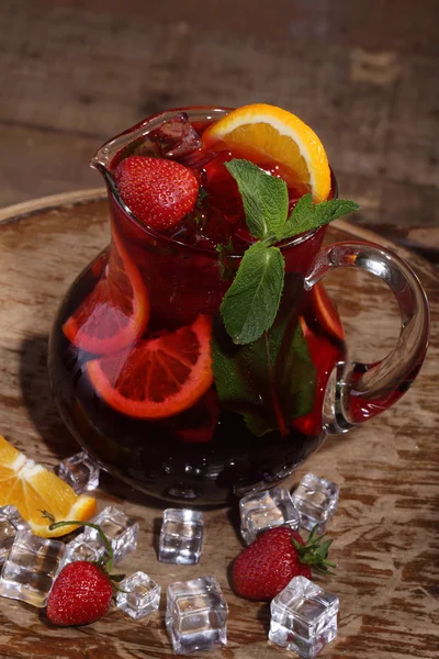 Vino de Sangrija en una jarra transparente con una fresa, un oran — Foto de Stock