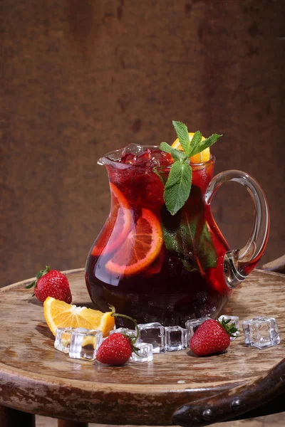 Wein aus Sangrija in einem durchsichtigen Krug mit einer Erdbeere, einem Orangensaft — Stockfoto