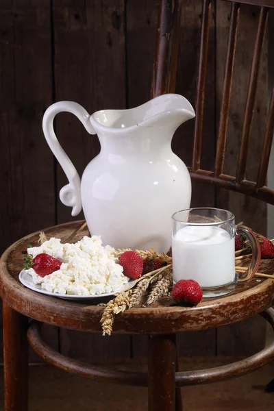 Milk in a transparent mug, cottage cheese and a ripe strawberry — Stockfoto