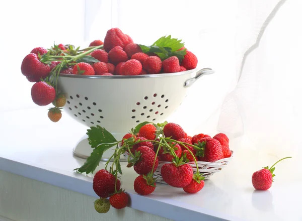 Strawberry in a wattled cup on a white window sill — Stock Photo, Image