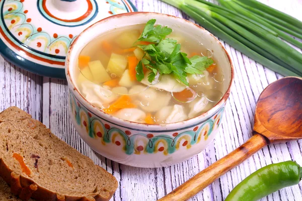 Soup with pelmeni, a potato, carrots submitted with a green onio — Stock Photo, Image