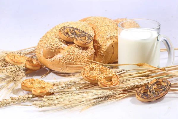 Milk and roll from wheat flour of a house batch on a white backg — Stock Photo, Image