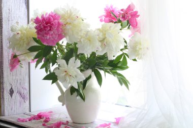 Bir sürahi bir beyaz pencere sil üzerinde beyaz ve pembe peonies buket