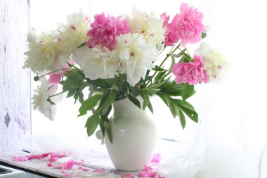Bir sürahi bir beyaz pencere sil üzerinde beyaz ve pembe peonies buket