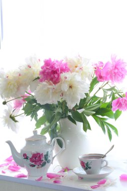 Çay ve bir beyaz pencere s peonies bir buket ile natürmort