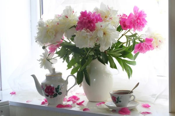 Still-life with tea and a bouquet of peonies on a white window s — Stock Photo, Image