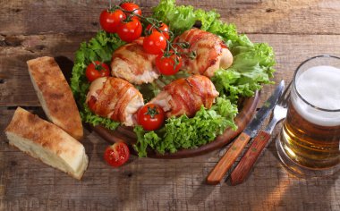 Gönderilmiş pastırmalı tavuk Tokmaklar ve şeffaf bir kupa bira