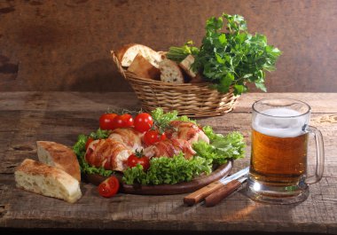 Gönderilmiş pastırmalı tavuk Tokmaklar ve şeffaf bir kupa bira