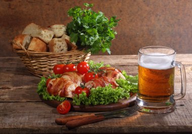 Gönderilmiş pastırmalı tavuk Tokmaklar ve şeffaf bir kupa bira