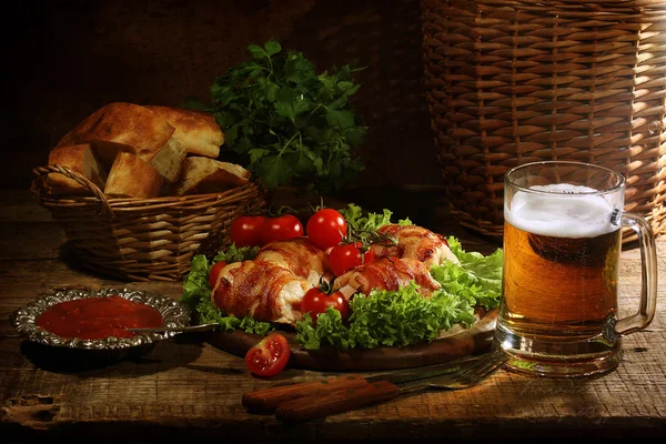 Beer in a transparent mug and chicken beaters in bacon submitted — Stock Photo, Image