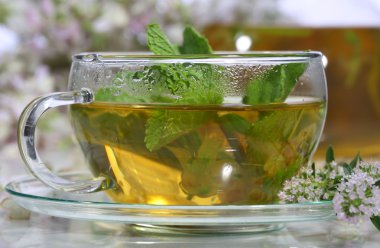 Güzel kokulu otlar ve şeffaf bir fincan nane ile tıbbi çay