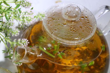  Otlar ve nane beyaz ba üzerinde şeffaf bir demlik çay