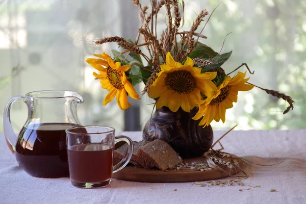 Stillleben mit einem Strauß Sonnenblumen und Kvass (kvas) in — Stockfoto