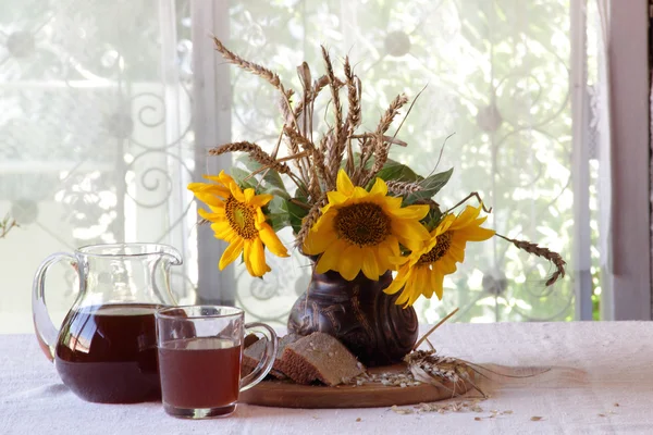 Stilleven met een boeket van zonnebloemen en Kvas (kvas) in — Stockfoto