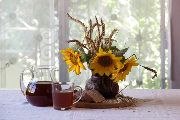 Stilleven met een boeket van zonnebloemen en Kvas (kvas) in — Stockfoto