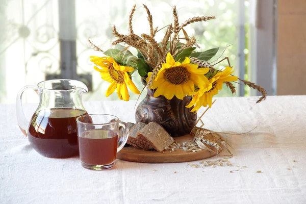 Stillleben mit einem Strauß Sonnenblumen und Kvass (kvas)) — Stockfoto