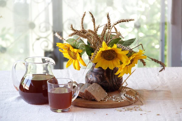 Stilleven met een boeket van zonnebloemen en Kvas (kvas) — Stockfoto