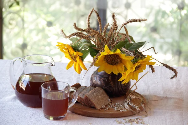 Stilleven met een boeket van zonnebloemen en Kvas (kvas) — Stockfoto