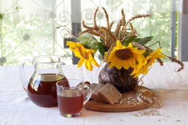 Natürmort Kvas (kvas) şeffaf bir sürahi ve bir buket ile 