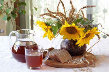Natürmort Kvas (kvas) şeffaf bir sürahi ve bir buket ile 
