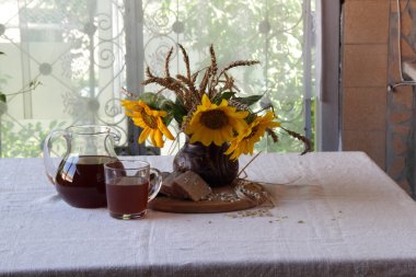 Natürmort Kvas (kvas) şeffaf bir sürahi ve bir buket ile 