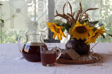 Natürmort Kvas (kvas) şeffaf bir sürahi ve bir buket ile 