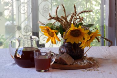 Natürmort Kvas (kvas) şeffaf bir sürahi ve bir buket ile 