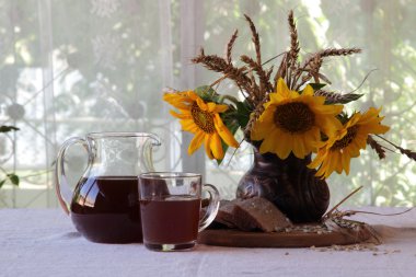 Natürmort Kvas (kvas) şeffaf bir sürahi ve bir buket ile 