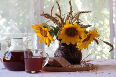 Natürmort Kvas (kvas) şeffaf bir sürahi ve bir buket ile 