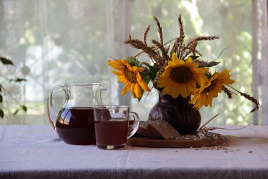 Natürmort Kvas (kvas) şeffaf bir sürahi ve bir buket ile 