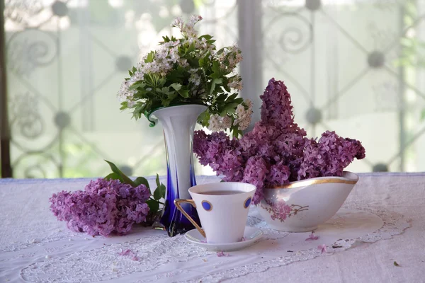 Bodegón sobre una lila y una taza de té — Foto de Stock