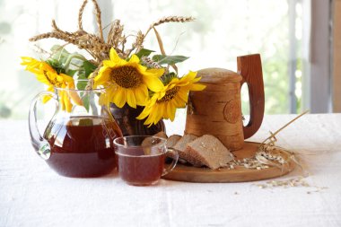 Kvas (kvas) ahşap bir kupa, ekmek ve ayçiçeği bir buket 