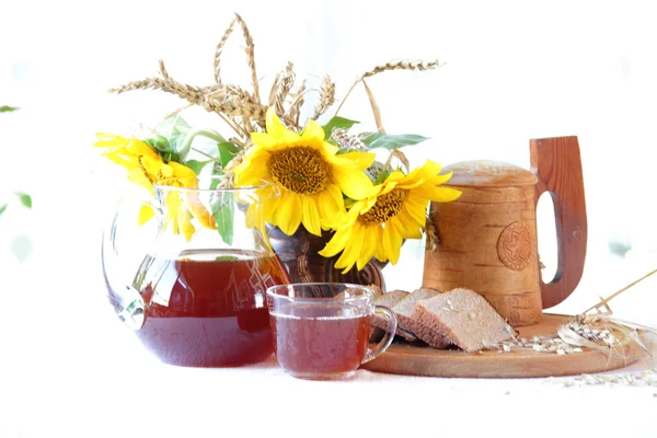 木製のマグカップ、パン、ひまわりの花束でクワス (kvas) — ストック写真