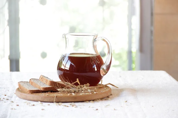 Kvass (kvas) in a transparent jug and rye bread — Stock Photo, Image