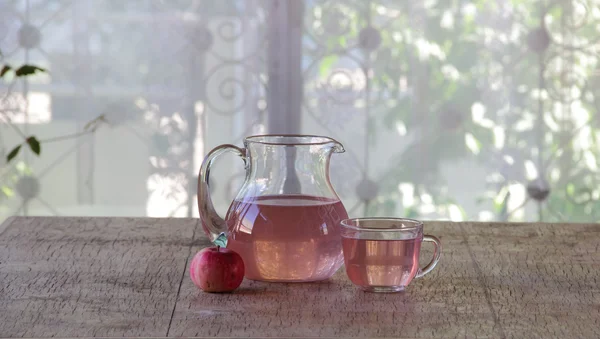 Compota de manzanas frescas en una jarra transparente sobre una mesa de madera —  Fotos de Stock