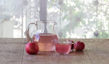 Kırmızı elma ve elma kompostosu bir ahşap ta sürahi içinde şeffaf bir