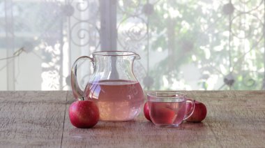 Kırmızı elma ve elma kompostosu bir ahşap ta sürahi içinde şeffaf bir