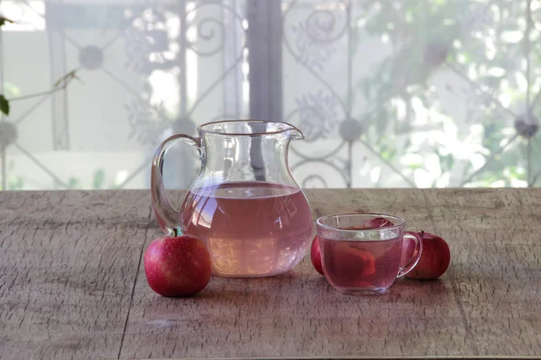 Manzanas rojas y compota de manzana en una jarra transparente sobre una ta de madera —  Fotos de Stock