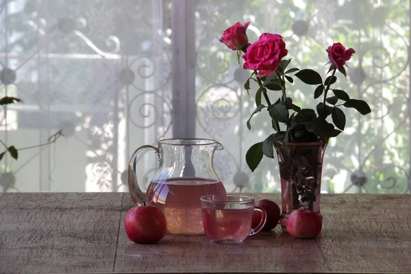 Compota de manzanas frescas en una jarra y un ramo de rosas —  Fotos de Stock